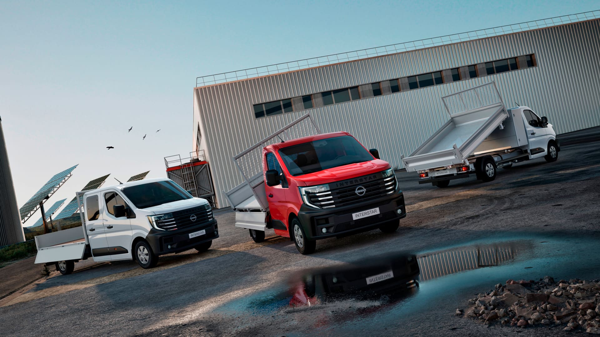 Nissan INTERSTAR-varevogne og tilpasninger parkeret foran solceller